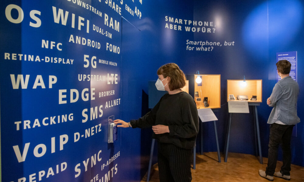 Blick in den Ausstellungsbereich Smart(e) Welten: zwei Besucher schauen sich die Ausstellung an