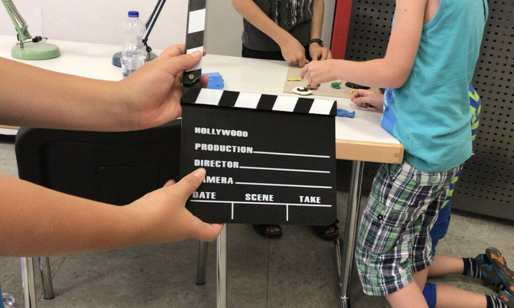 Kinderhände halten eine Filmklappe für die nächste Filmaufnahme